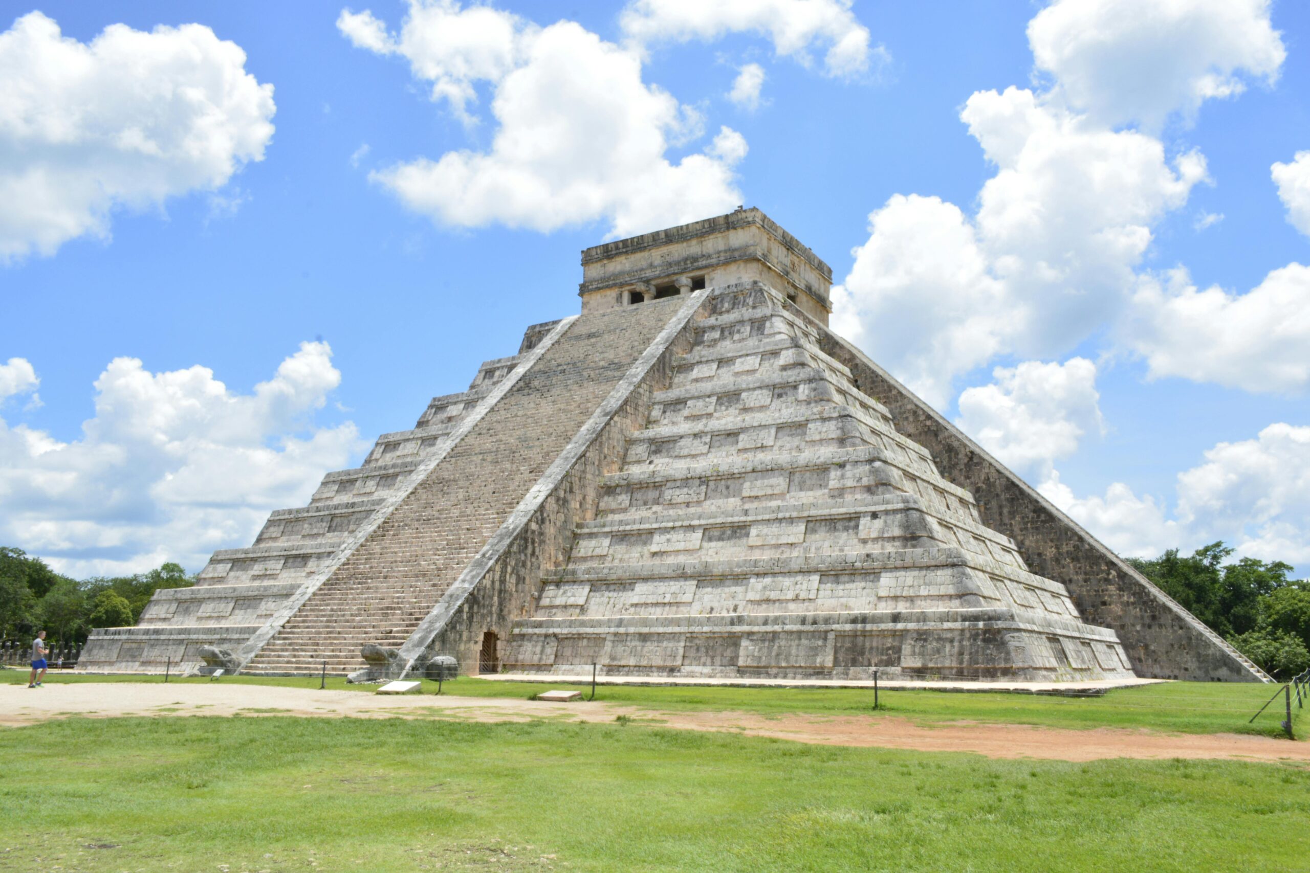Explore the iconic Pyramid of Chichén Itzá, Yucatán, an architectural marvel under a vibrant blue sky.