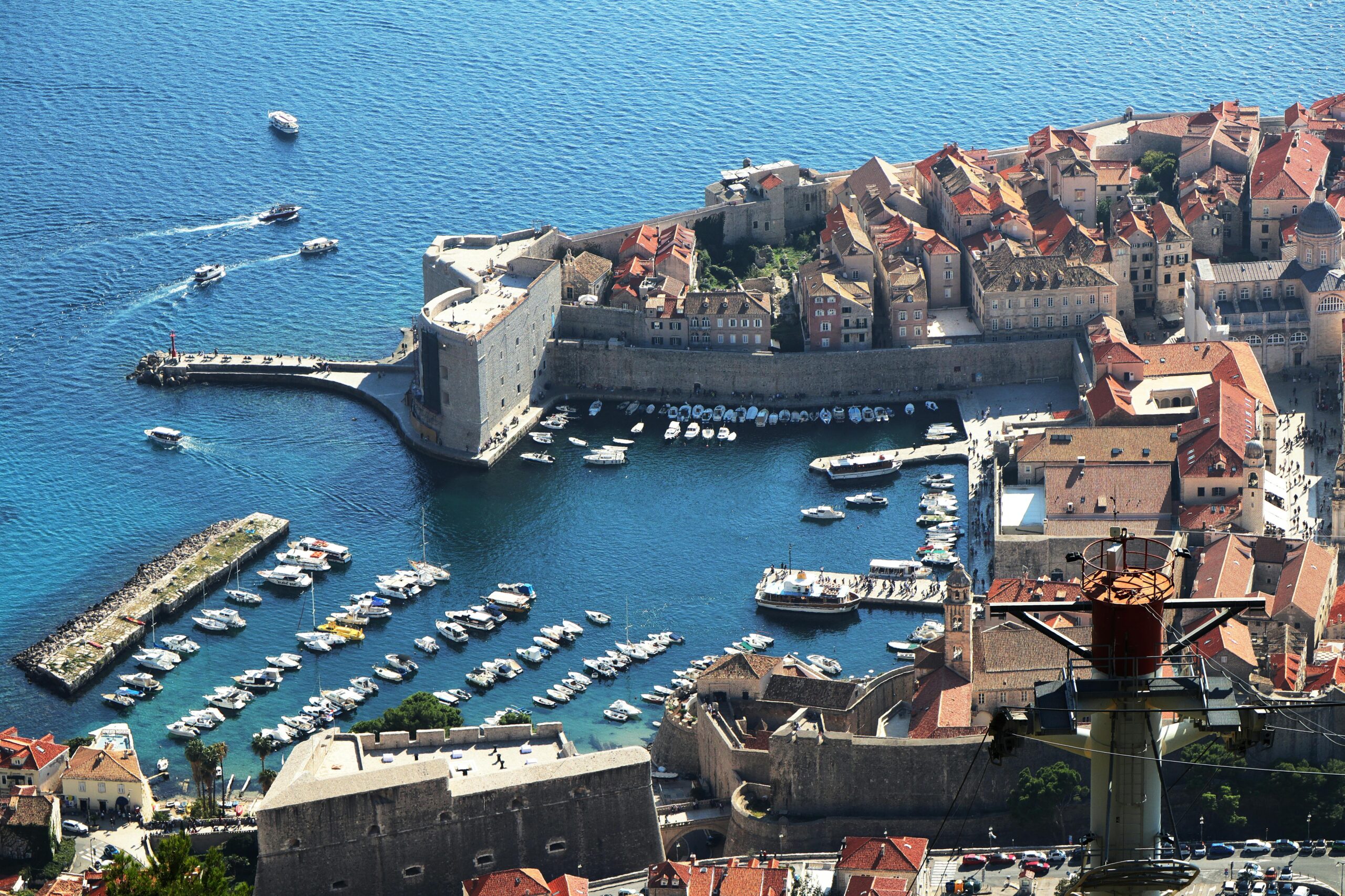 A stunning aerial view of Dubrovnik's Old Town and marina, showcasing the city's medieval architecture along Croatia's coast.